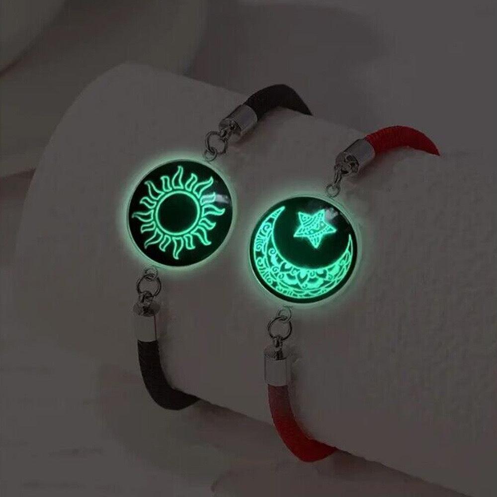 Motifs de soleil et de lune lumineux sur des bracelets avec des sangles noires et rouges.