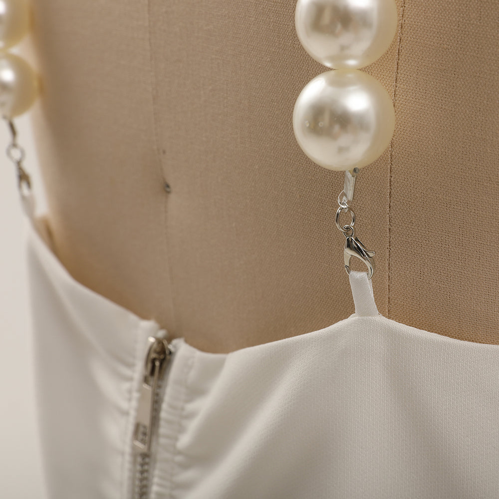 White garment with pearl-like beads on a beige background
