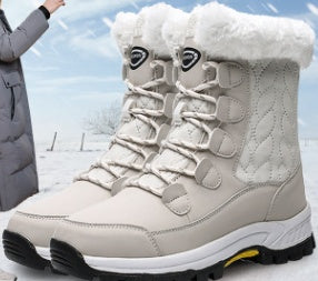 Pair of beige winter boots with white fur lining on a snowy background