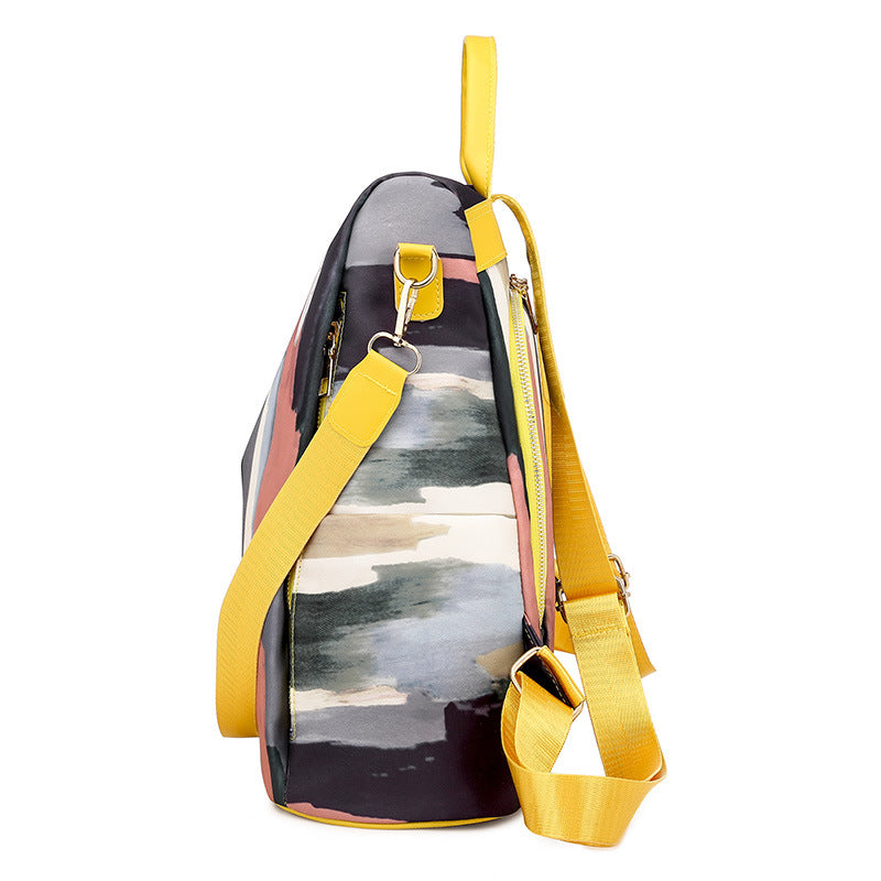 Backpack with yellow straps and a colorful design on a white background