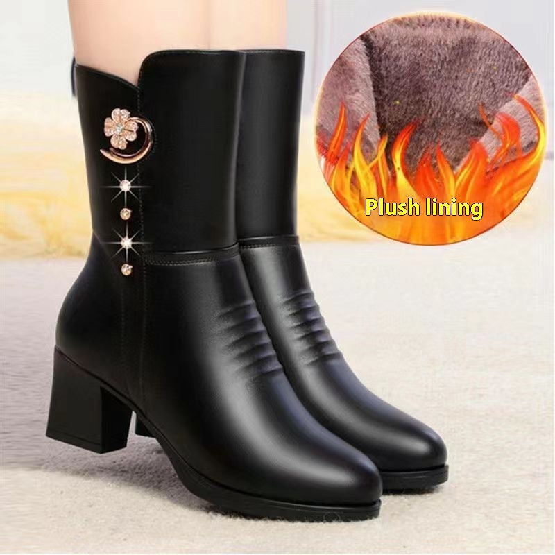Black ankle boots with decorative elements on a light background, showing plush lining detail.