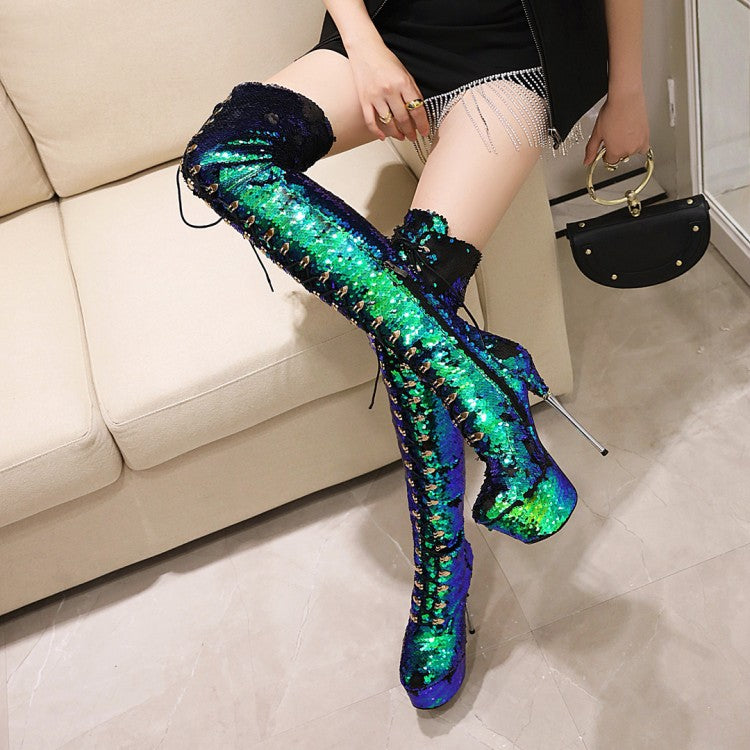 Person wearing colorful sequin boots in a room with a couch and handbag.
