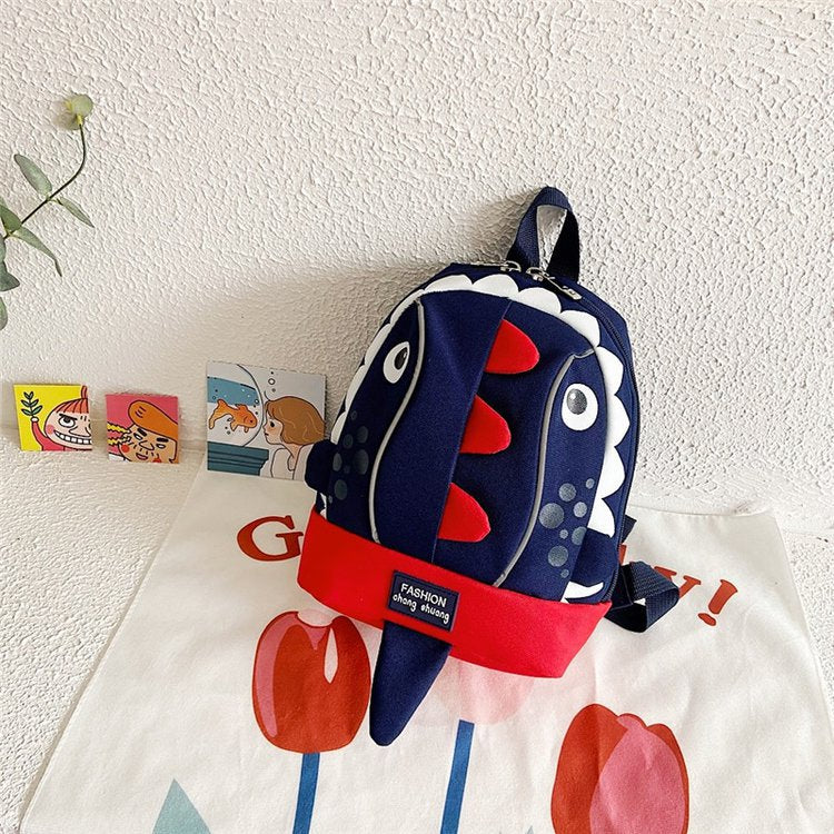Children's backpack with shark design on a white surface