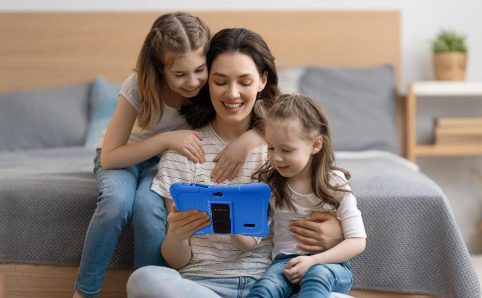 Woman and two children sitting on a bed using a tablet together.