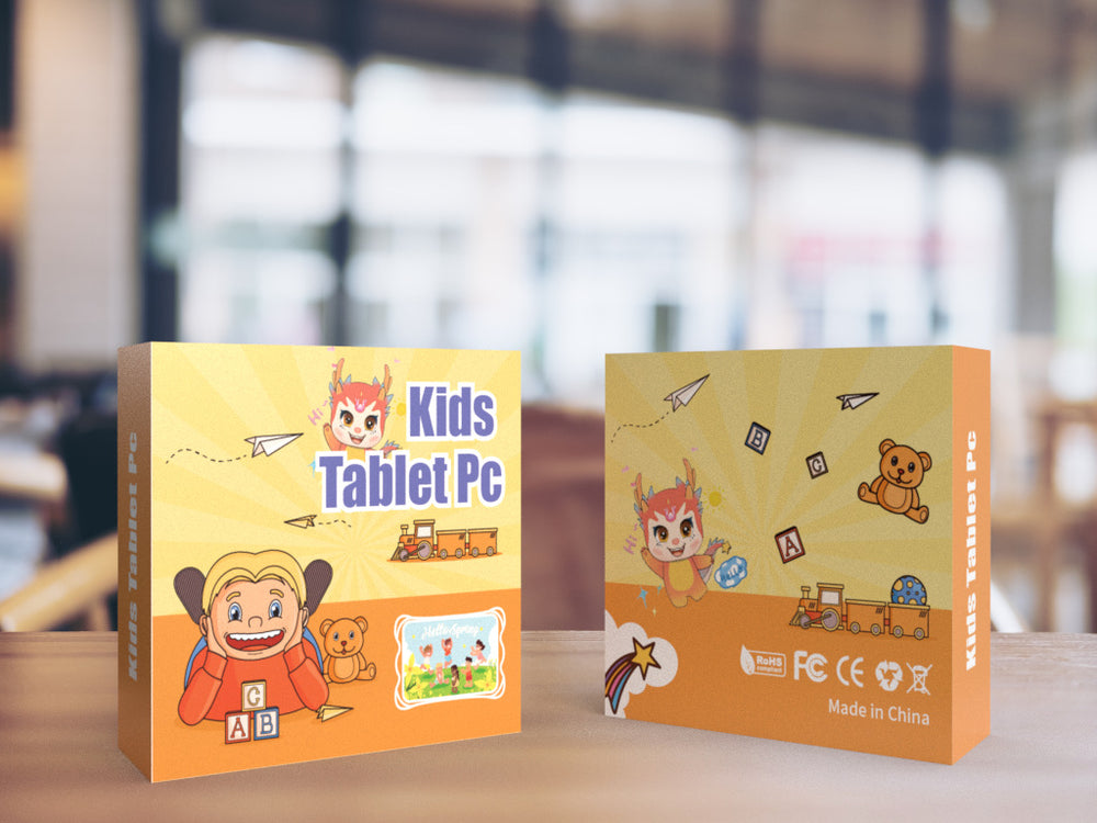 Two packaging boxes for a kids tablet PC on a wooden surface with a blurred indoor background.