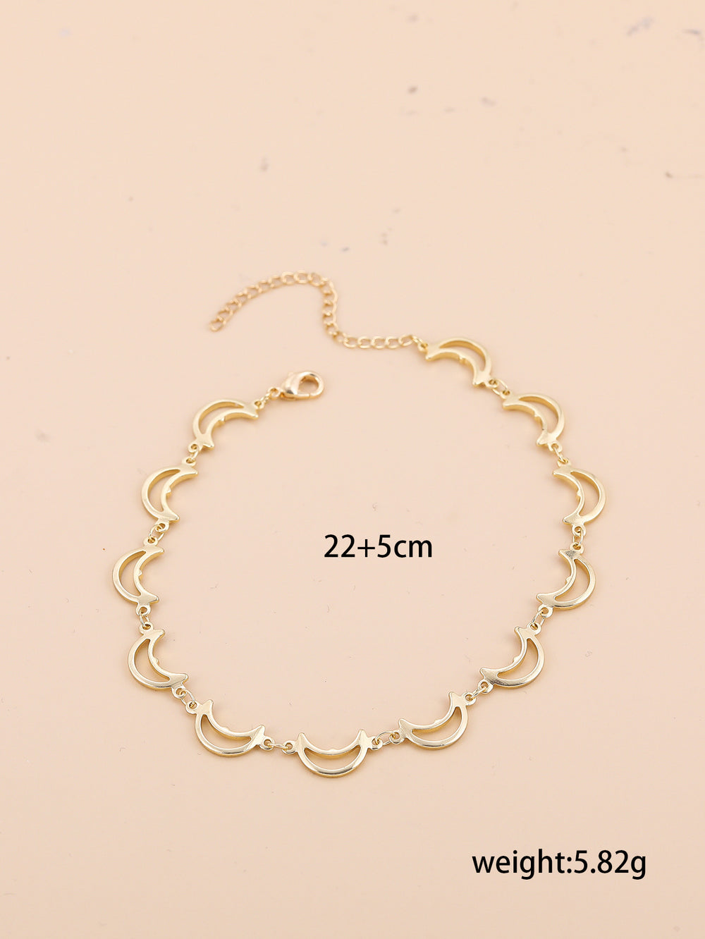 Gold necklace with measurements and weight on a beige background