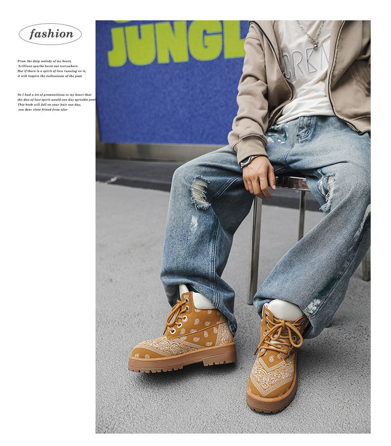 A person seated on a stool wearing tan lace-up boots with a white bandana pattern, light blue ripped jeans, a white T-shirt, and a beige zip-up hoodie. The photo is styled like a magazine fashion editorial with a blue background and the word 'JUNGLE' visible.