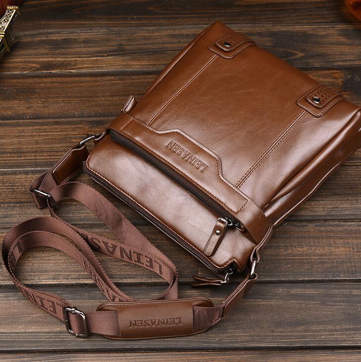 Brown leather crossbody bag on a wooden surface