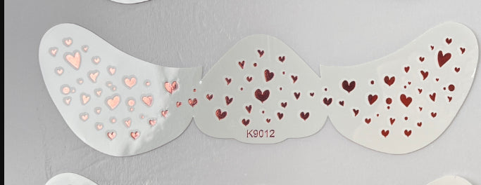Decorative heart-patterned wings with 'KG012' on a gray background