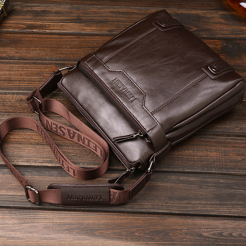 Brown leather bag with strap on a wooden surface