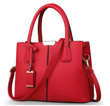 Red handbag with a strap on a white background