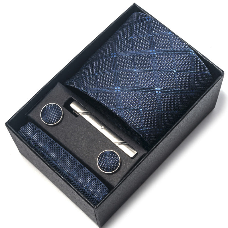 Blue patterned tie set with tie clip and pen in a black box on a white background