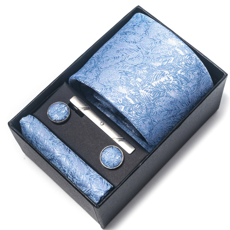 Blue patterned tie set with tie clip and cufflinks in a black box on a white background