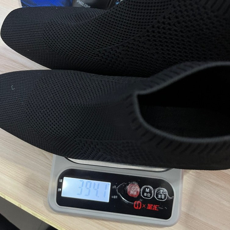 Chaussures noires pesées sur une balance numérique avec un arrière-plan flou