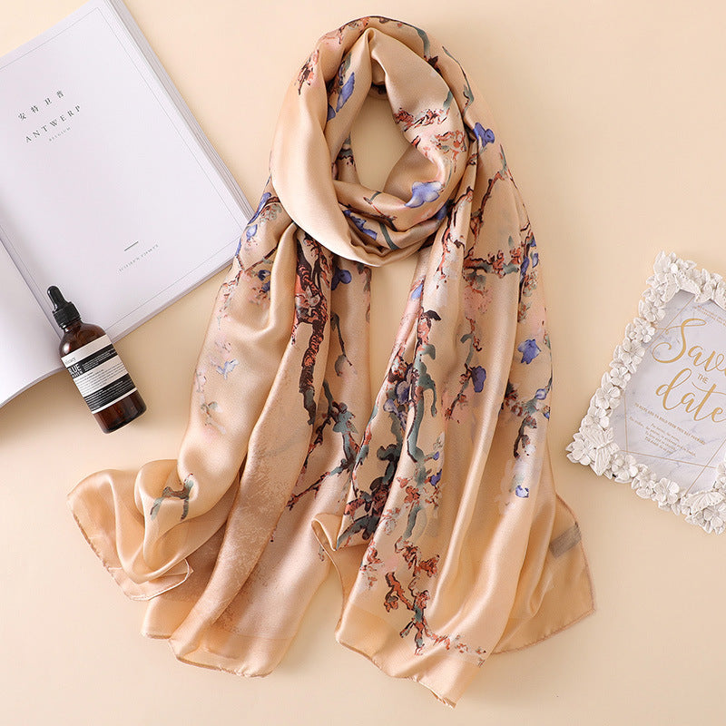 Floral patterned scarf on a beige surface with a bottle and card.