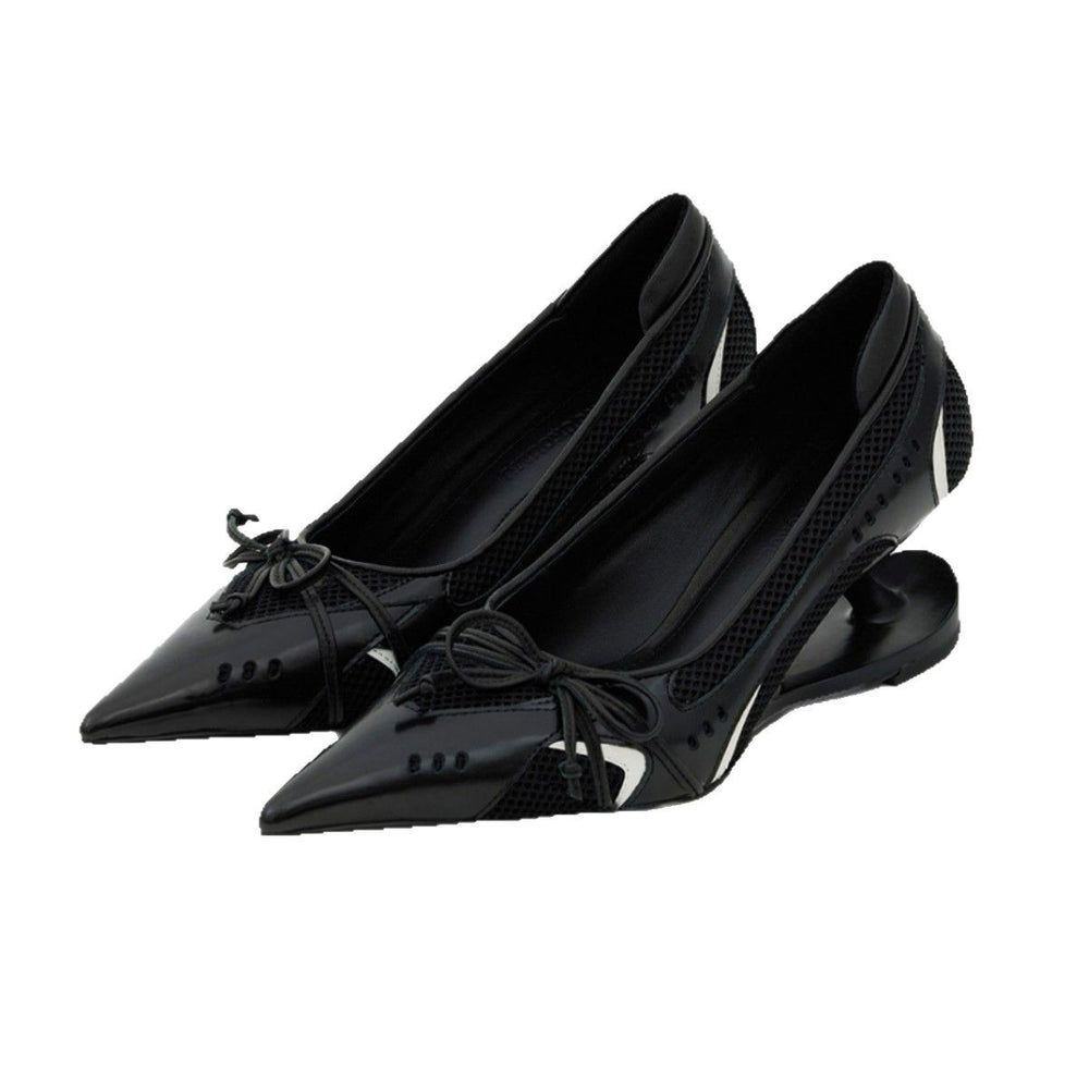 Black pointed-toe shoes with bow details on a white background