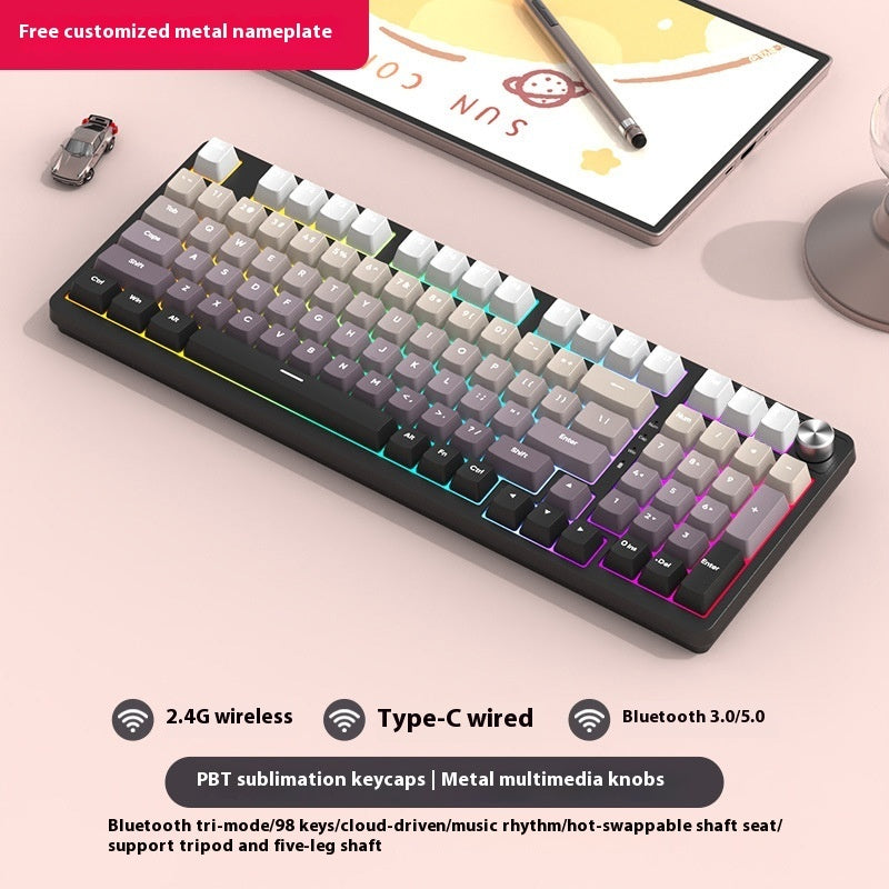 Mechanical keyboard with RGB lighting on a desk with a tablet and smartphone in the background.