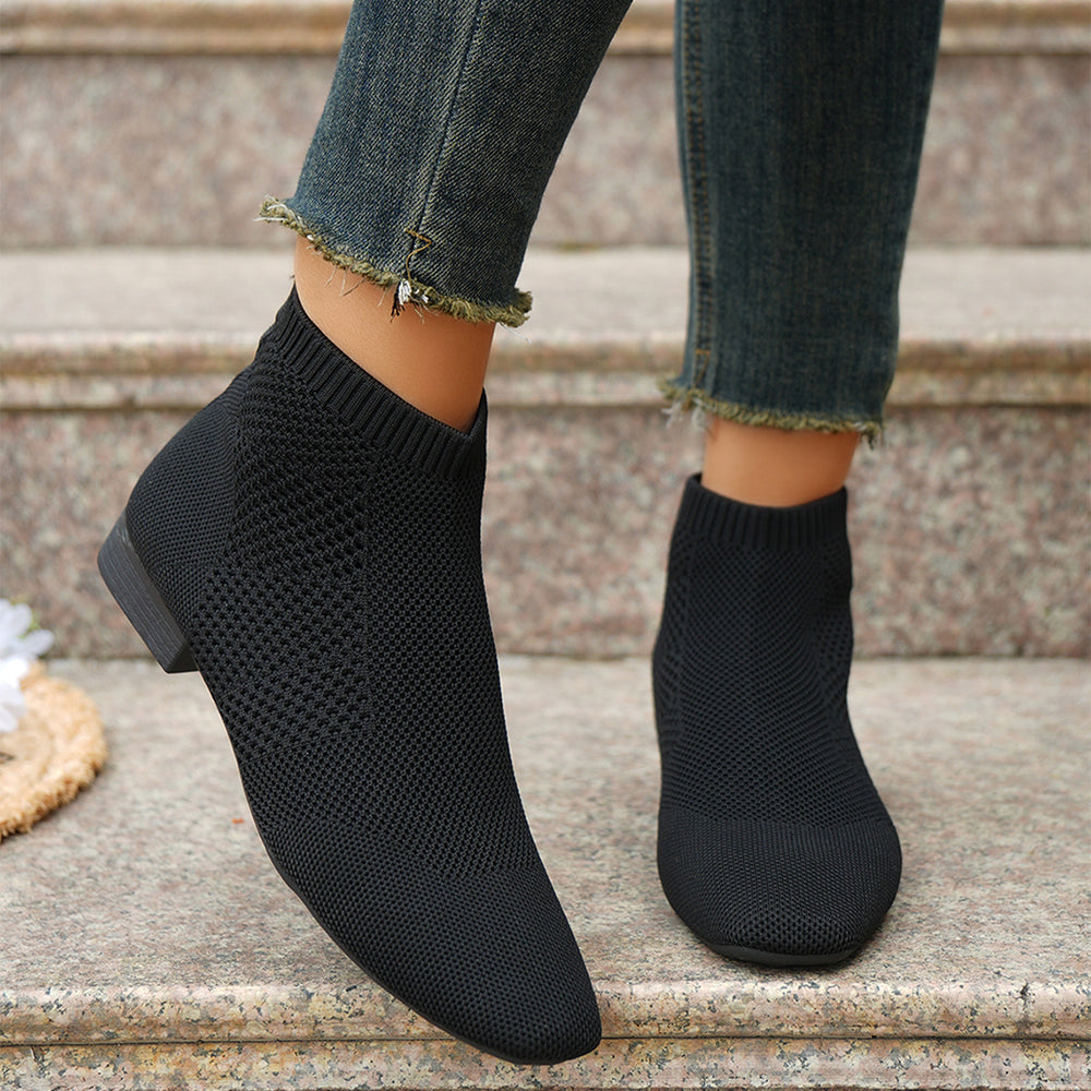 Bottes chaussettes noires portées avec un jean sur une marche en pierre