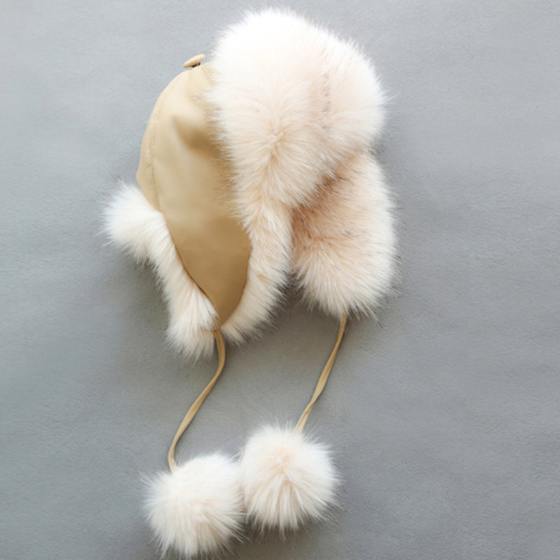 Beige winter hat with fur accents on a gray background