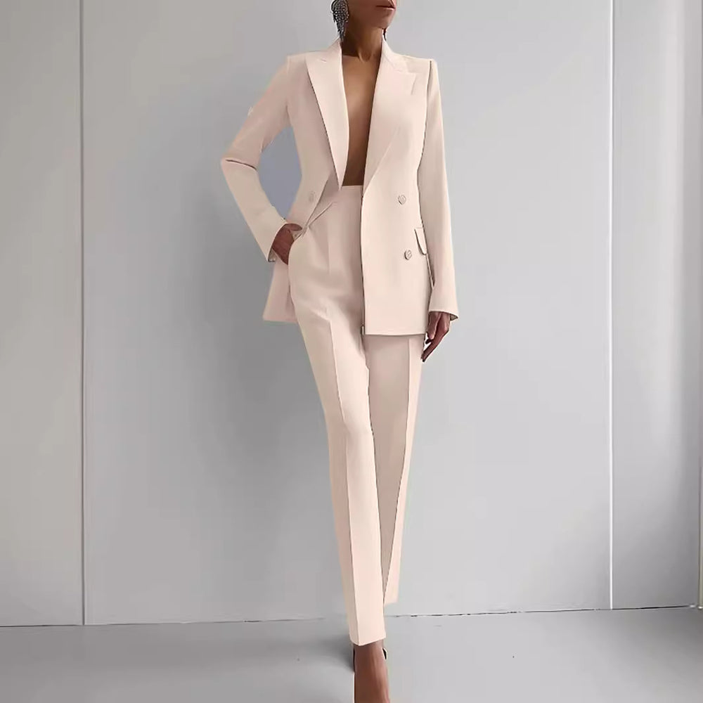 Person wearing a light pink suit against a gray background