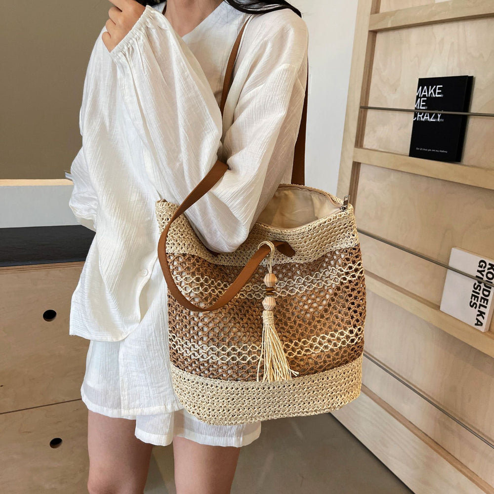 Person holding a woven handbag with a neutral background