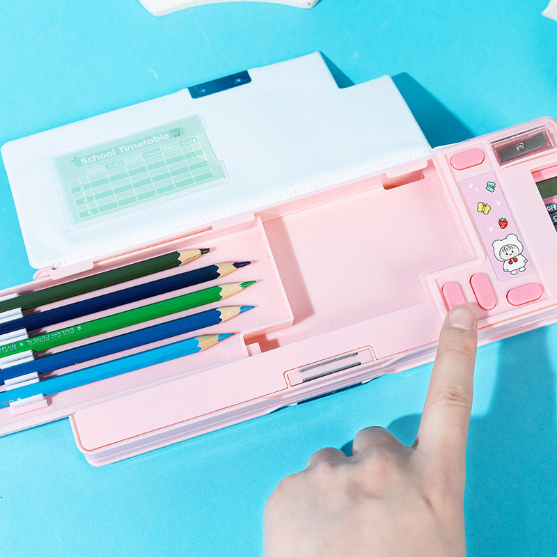 Pink stationery set with colored pencils and a small device on a blue background