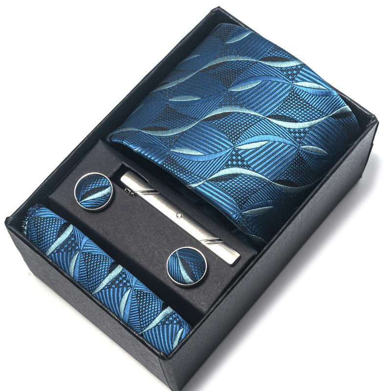 Blue patterned tie set with tie, tie clip, and cufflinks in a black box on a white background