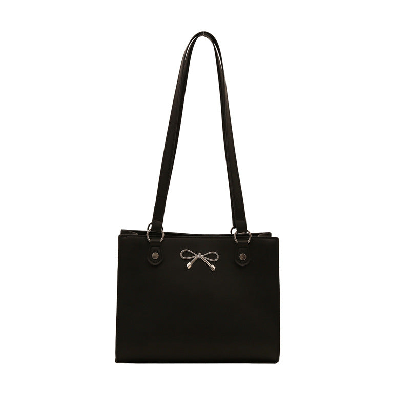 Black handbag with a bow detail on a white background