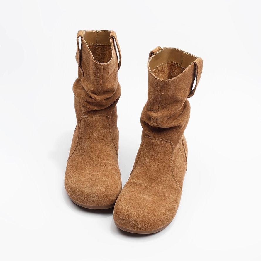Paire de bottes en daim marron sur un fond blanc
