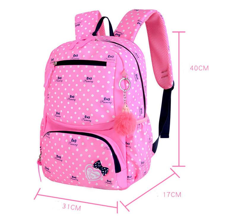 Pink polka dot backpack with measurements on a white background