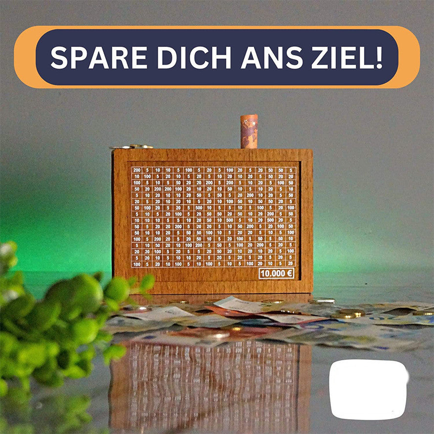 Wooden savings board with money on a reflective surface, text 'SPARE DICH ANS ZIEL!' at the top.