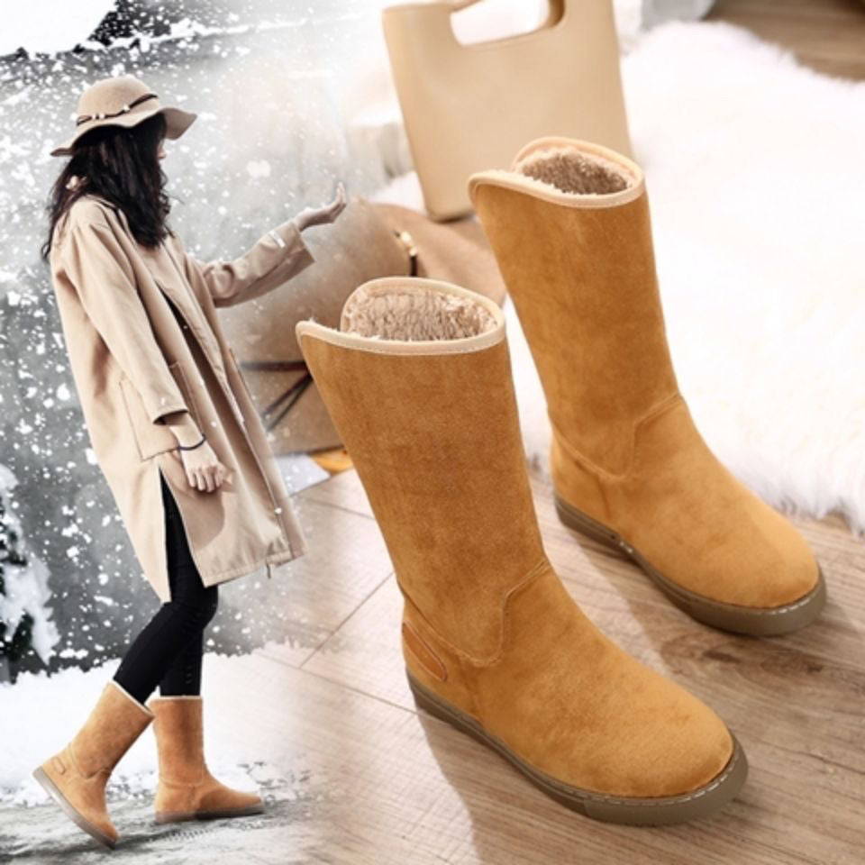 Pair of tan winter boots with a blurred snowy background