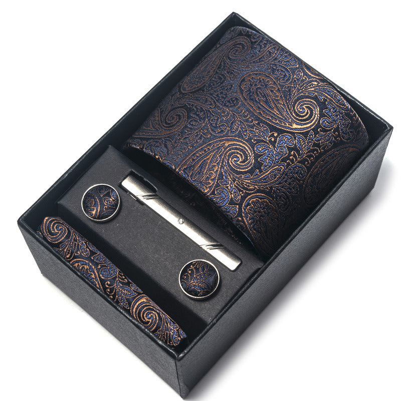 Paisley patterned tie, tie clip, and cufflinks set in a black box.