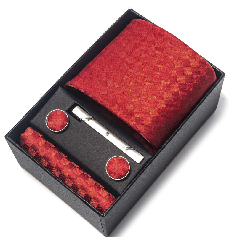 Red patterned tie set with tie clip and cufflinks in a black box on a white background