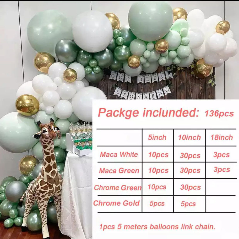 Balloon arch with green, white, and gold balloons and a table with a giraffe decoration.