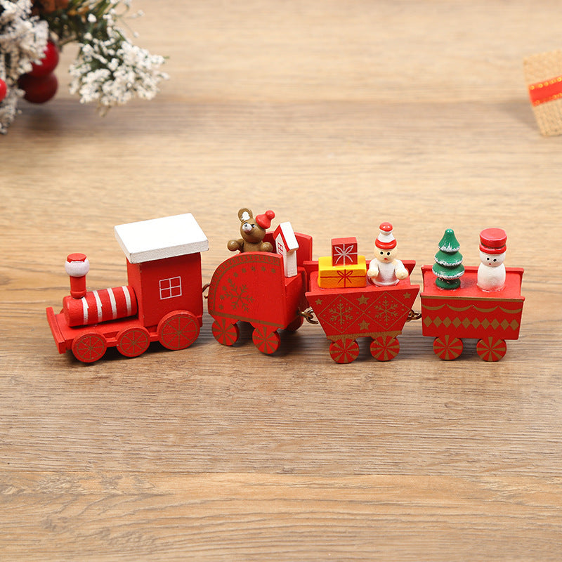 Wooden toy train set with Christmas-themed figures on a wooden surface