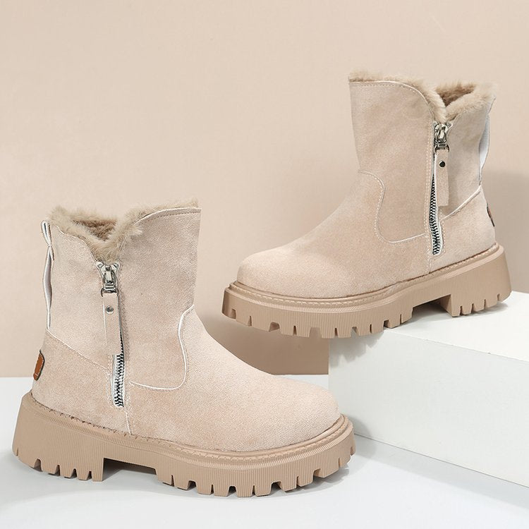 Beige winter boots with fur lining and zippers on a light beige background