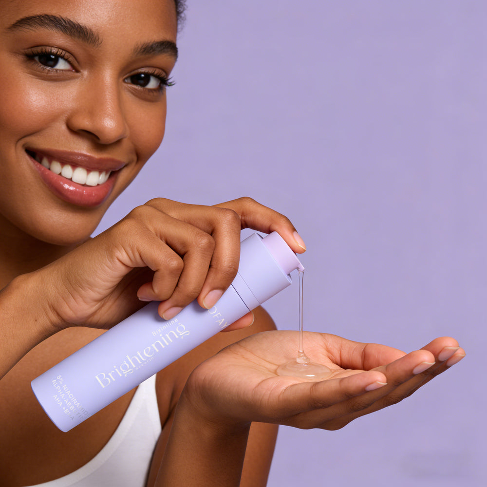 Woman holding a skincare product with a purple background