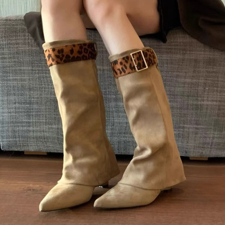 Beige knee-high boots with leopard print cuffs worn by a person sitting on a couch.