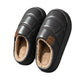 A pair of black slip-on winter slippers with a plush beige sherpa lining, shown from a top-down angle on a white background.