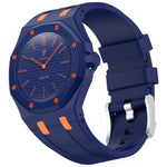 A luxury watch with a dark blue octagonal bezel, textured blue dial, and a matching blue silicone strap accented with orange details and a silver buckle.