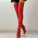 Red leather knee-high boots on a plain background