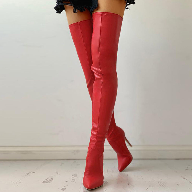 Red leather knee-high boots on a plain background