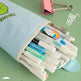 Open light blue pen holder with stationery items on a green background