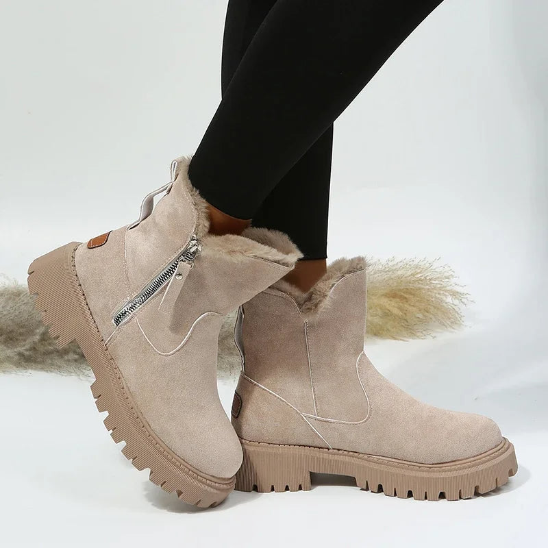 Beige winter boots with fur lining worn by a person on a light background