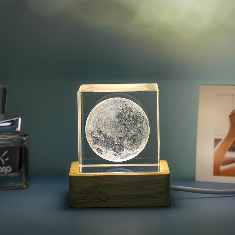 Moon-shaped crystal on a wooden base with a blurred background