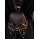 Brown leather backpack worn over a dark outfit