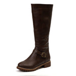 Brown knee-high boot with a buckle on a white background