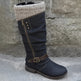 Black knee-high boot with a knit cuff on a stone surface