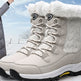 Pair of beige winter boots with white fur lining on a snowy background